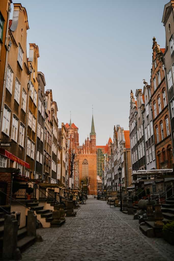 Charming street in Gdańsk, Poland, with historic architecture and cobblestone roads.