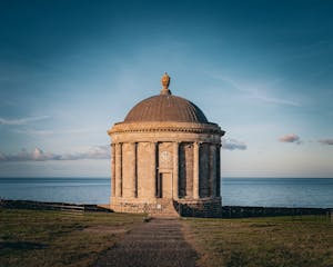 Historic Temple of Mussenden set against the ocean, captured at sunset with a clear sky.
