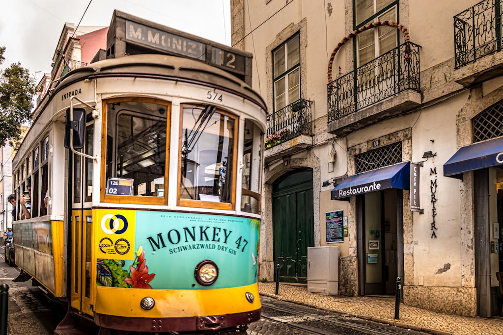 A vibrant Lisbon tram passes through a historic street, capturing the essence of Portugal's urban life.