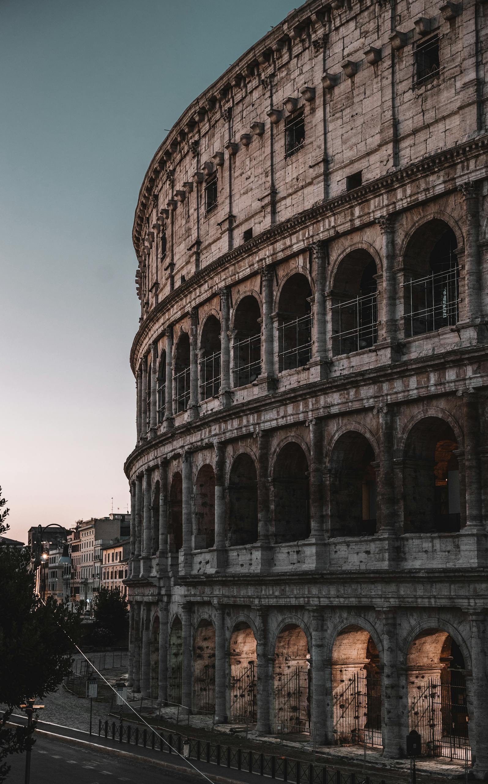 Majestic view of the Colosseum during twilight, showcasing Roman architectural brilliance in Rome, Italy.