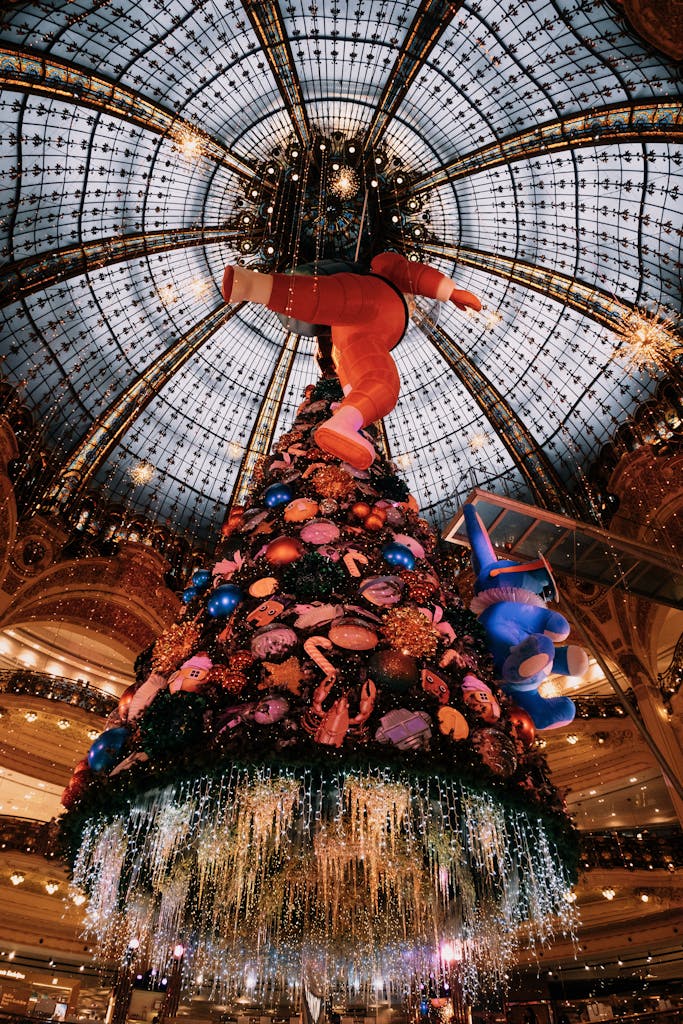 Photograph of a luxurious Christmas tree under a stunning glass dome ceiling, capturing festive decorations.