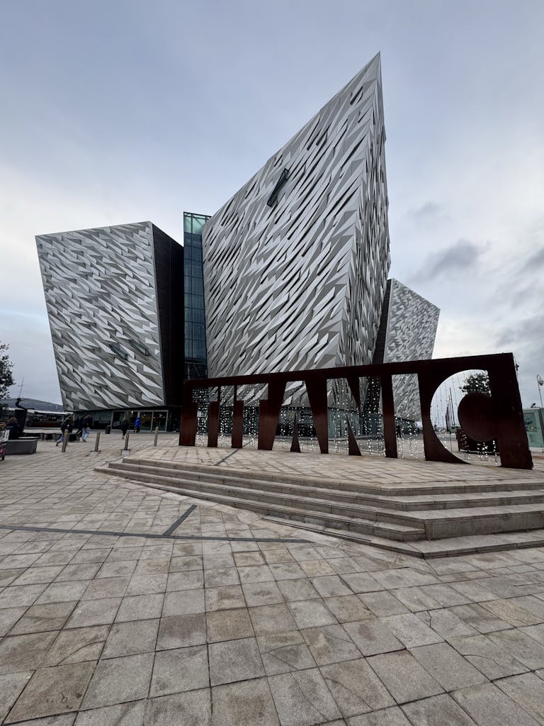 Striking modern architecture of Titanic Belfast museum with large sign.