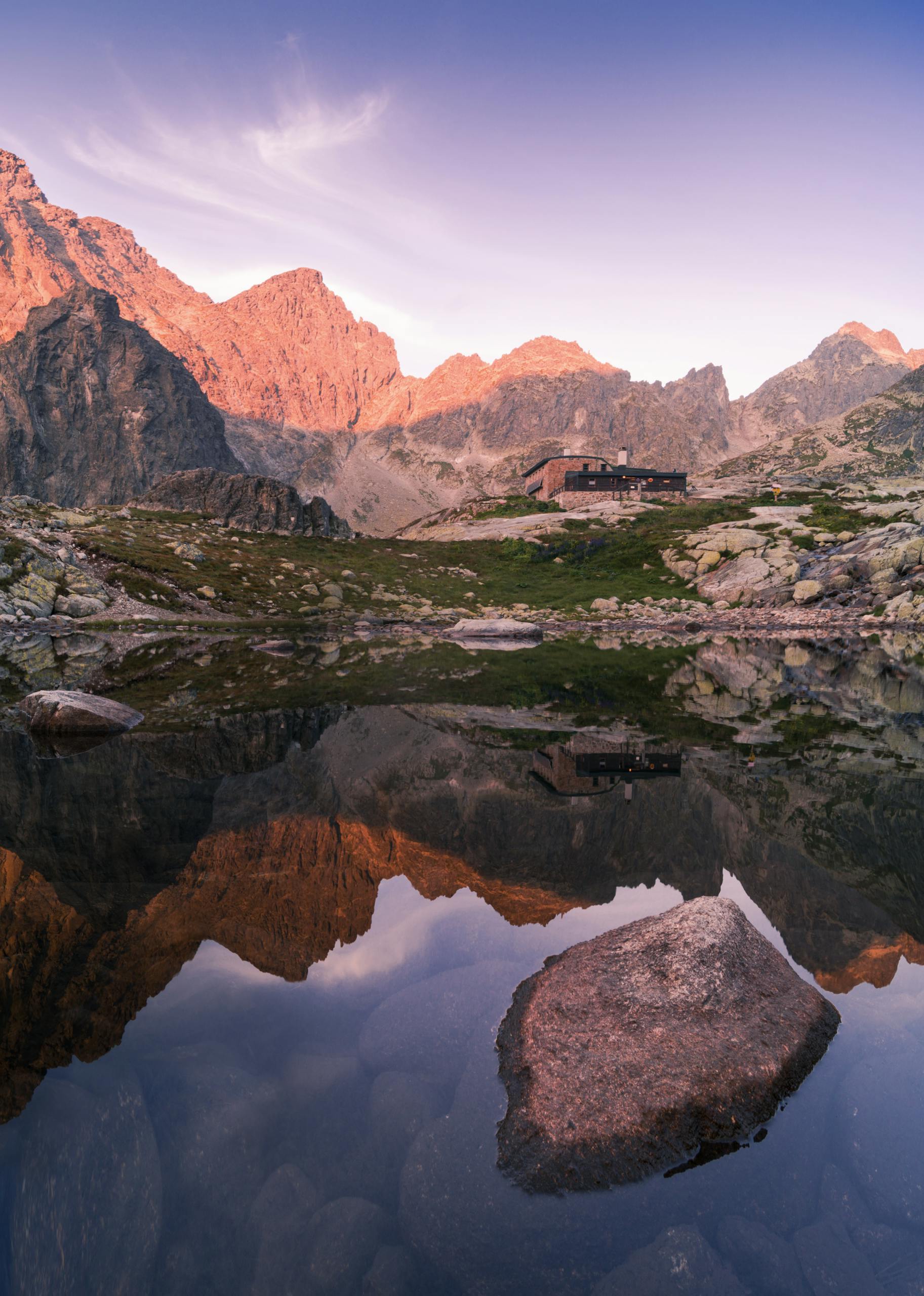 Breathtaking view of High Tatras at sunrise, reflecting off a tranquil lake.