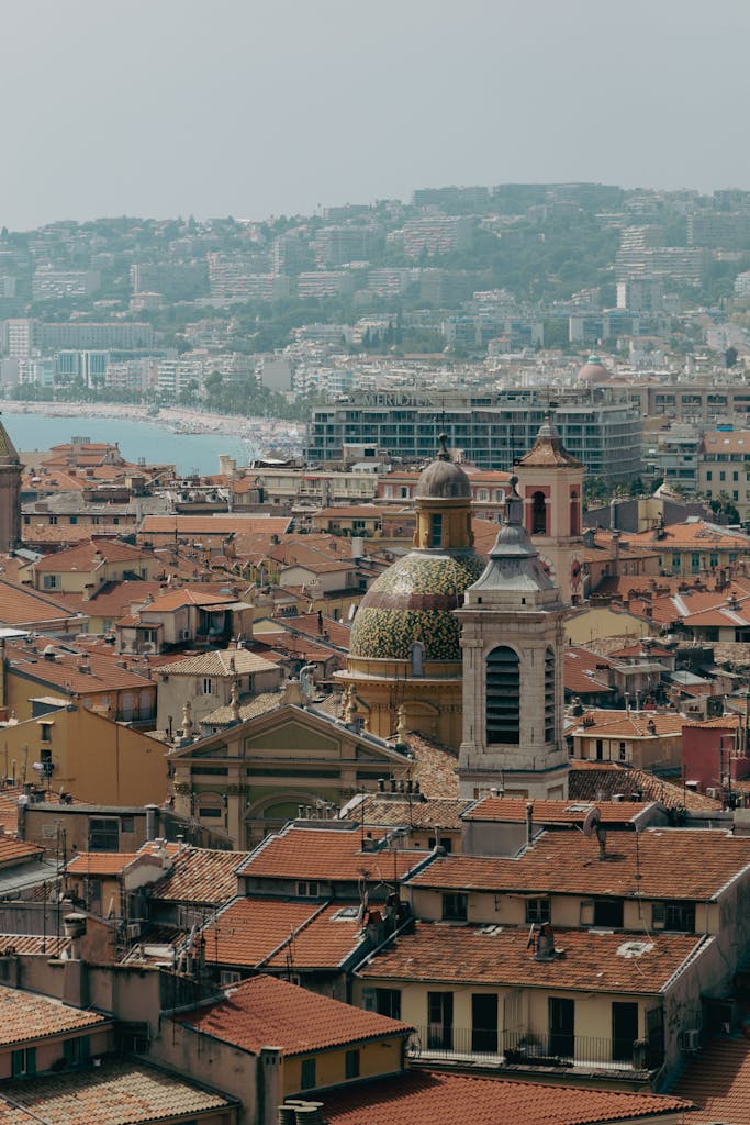 Discover the charming architecture of Nice, France with a panoramic view of its historic rooftops by the sea.