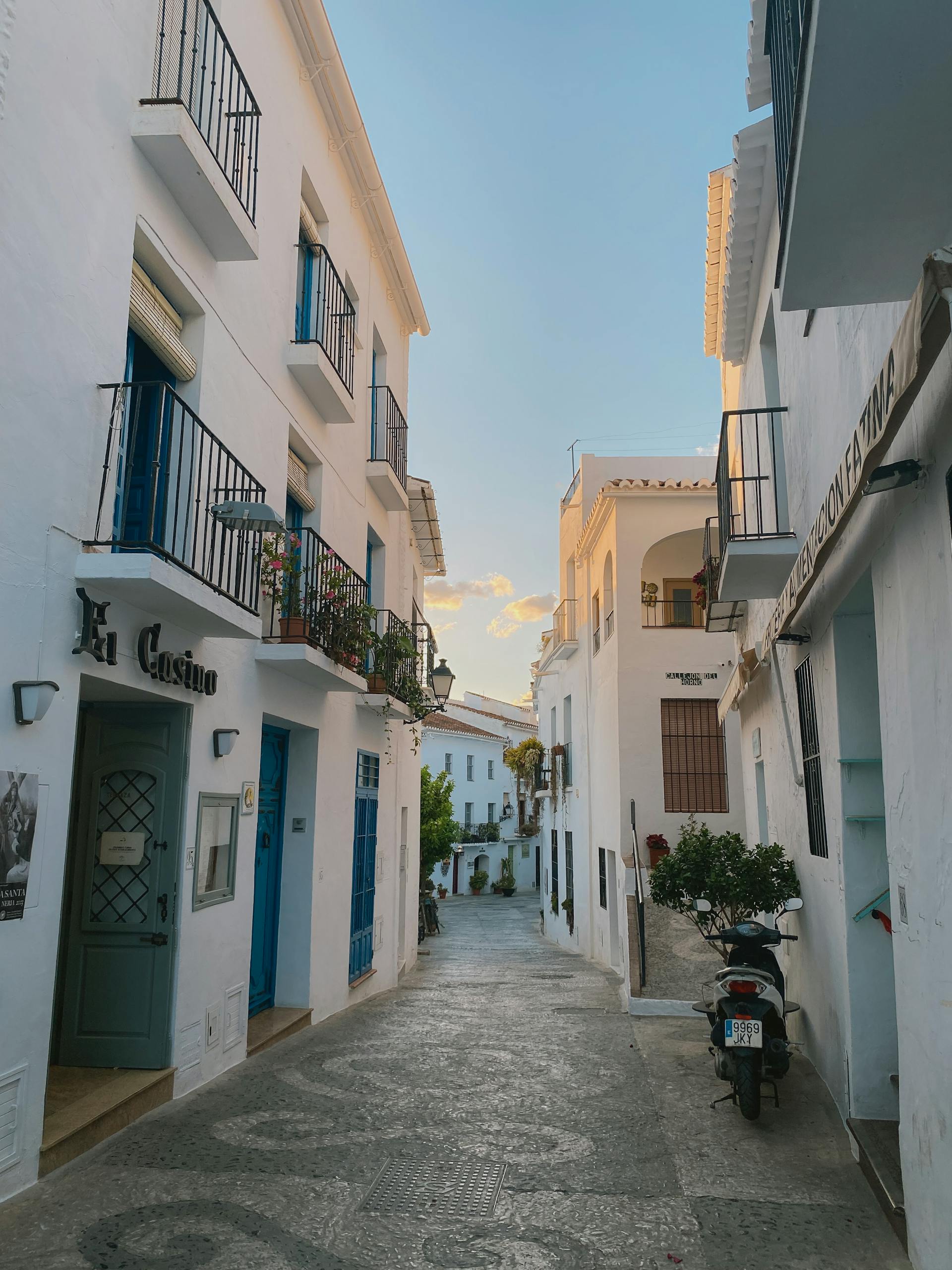 Discover the serene beauty of Frigiliana's white-washed streets at sunset in this picturesque scene.