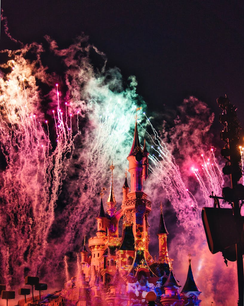 Vibrant fireworks illuminate the iconic Disneyland Paris castle at night.