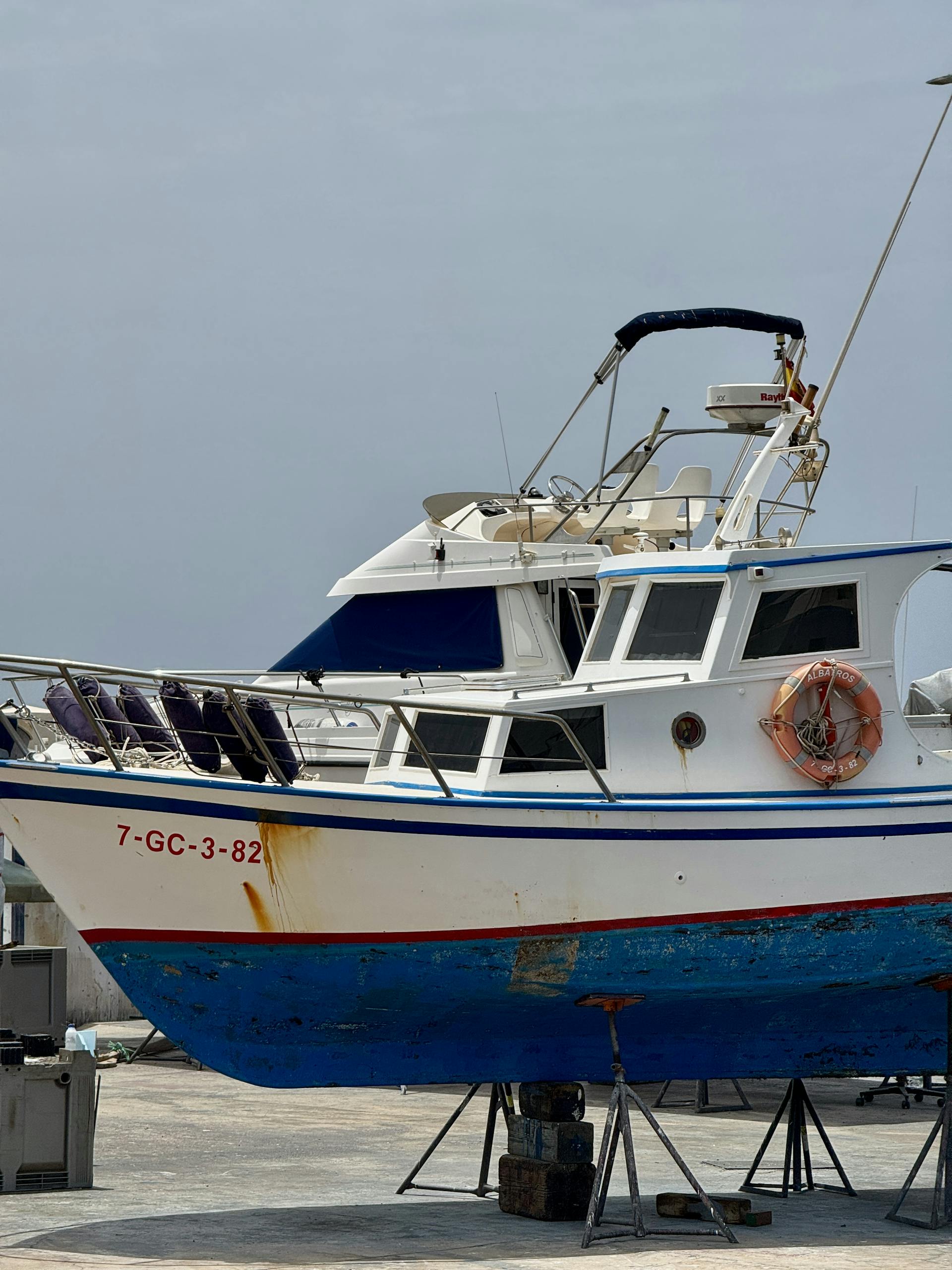 Colorful fishing boat docked at a harbor in Lanzarote, Spain under a clear sky.