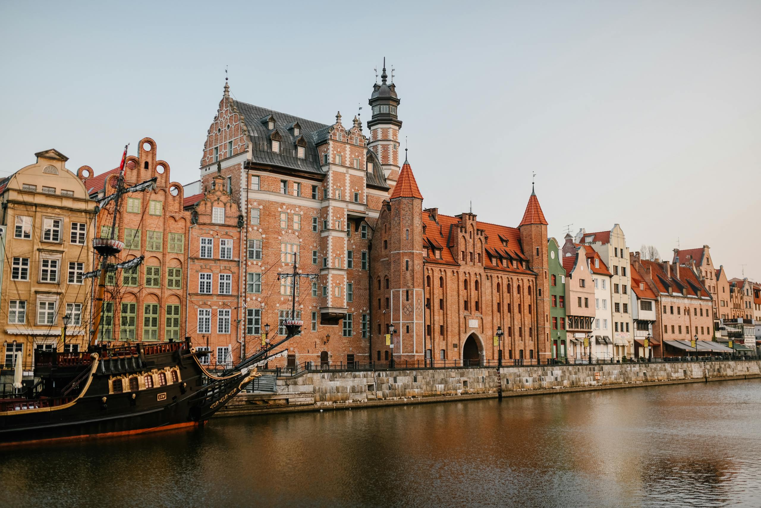 Scenic view of colorful historic buildings along the Motława River in Gdańsk, Poland.