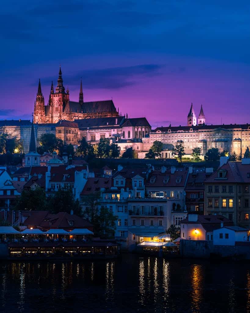 Twilight view of Prague Castle reflected in the Vltava River, showcasing a scenic Czechia cityscape.