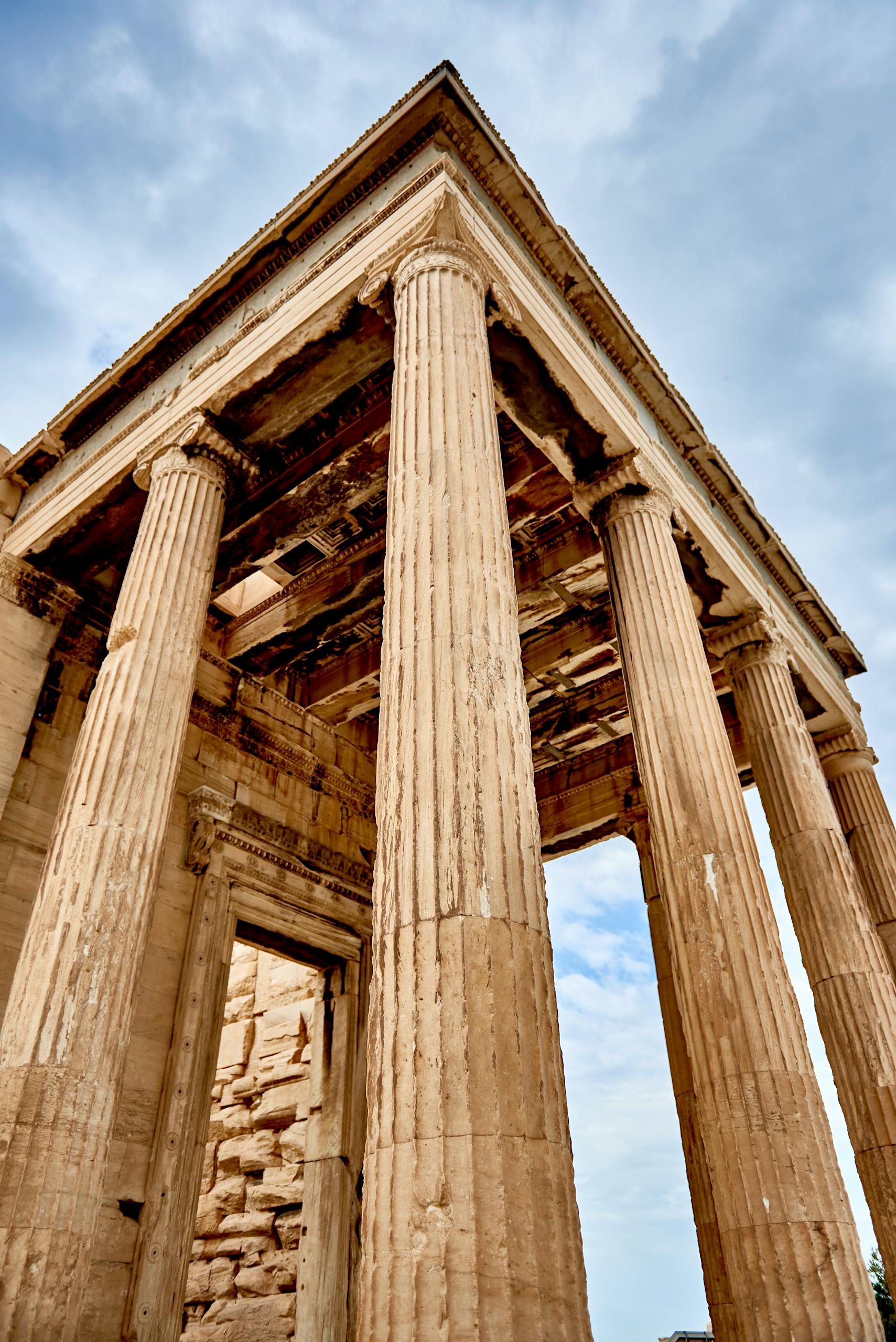 Low angle view of an ancient Greek temple's columns in Athens, showcasing historic architecture.
