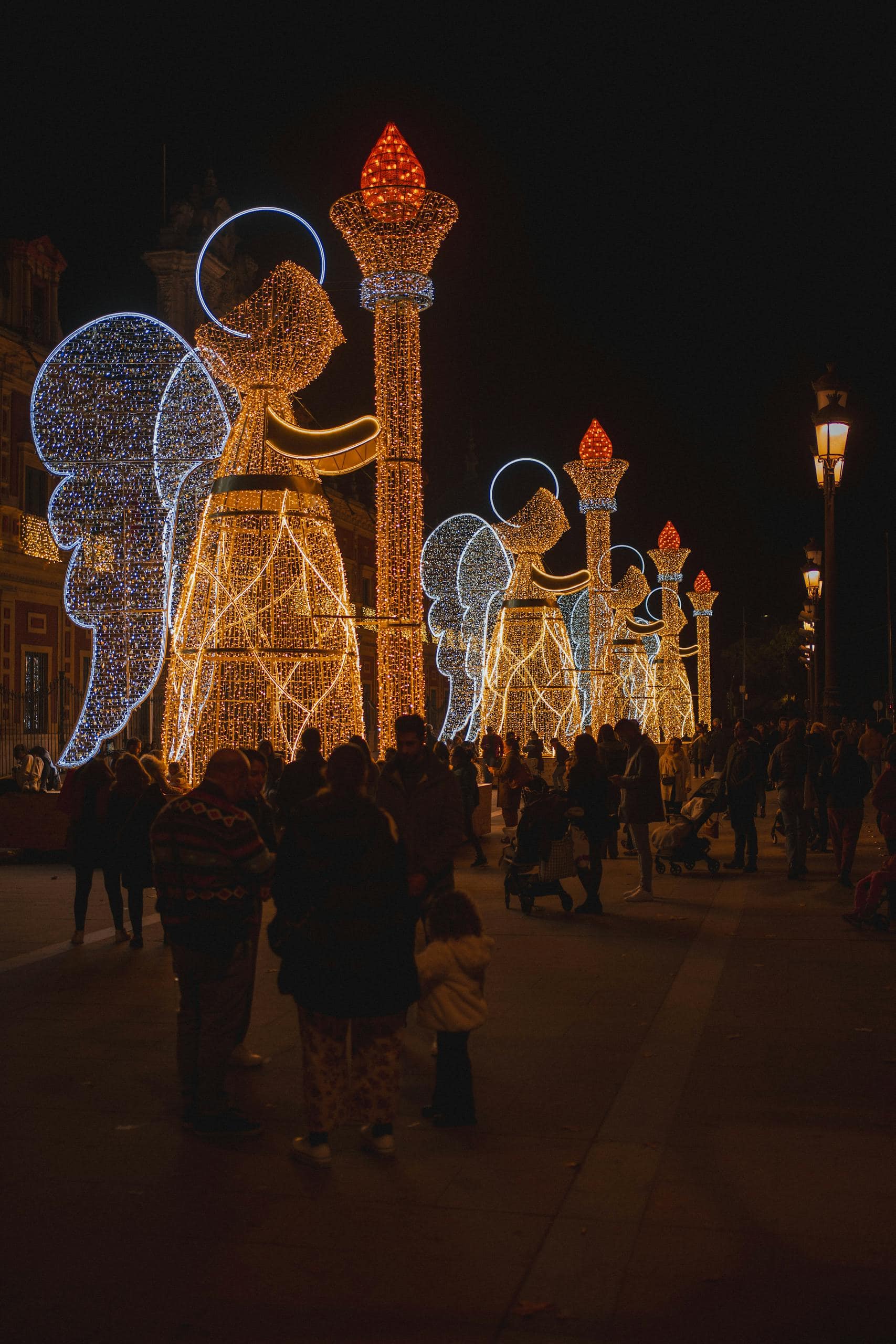 Illuminated angel decorations on Sevilla streets, capturing winter night ambiance.