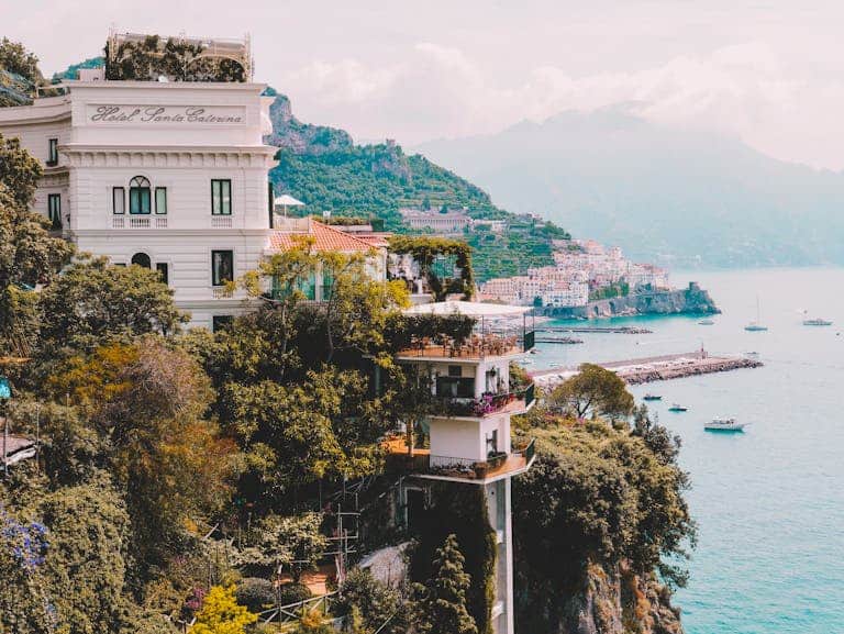Stunning view of Amalfi Coast with cliffs, buildings, and boats. Perfect for travel and architecture lovers.