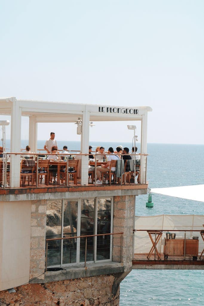 People dining at Le Plongeoir restaurant overlooking the sea in Nice, France.