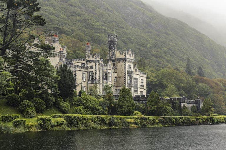 Beautiful view of Kylemore Abbey surrounded by lush greenery in Connemara, Ireland.