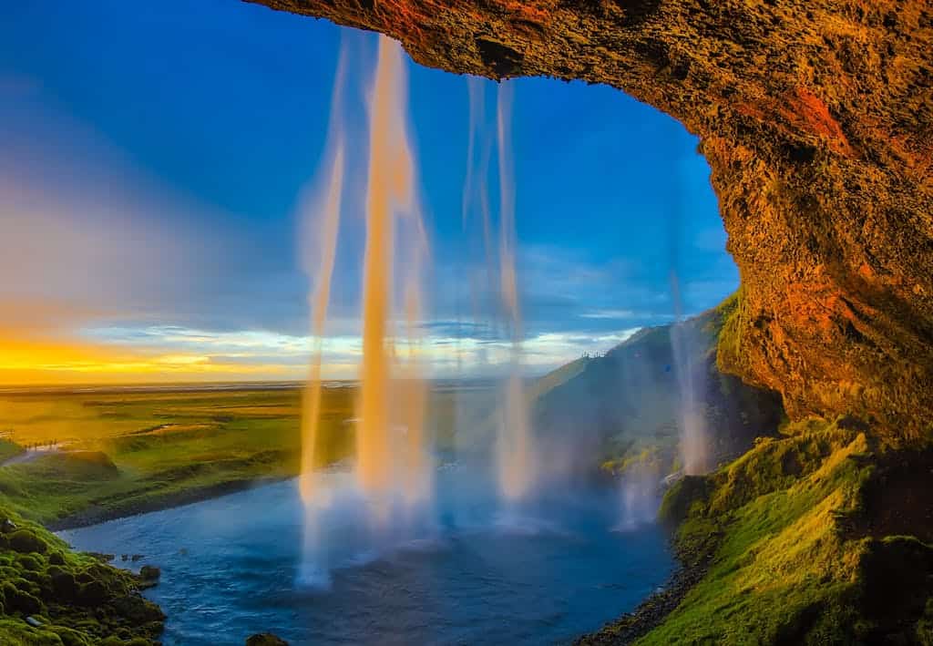 Magnificent view of Seljalandsfoss waterfall in Iceland against a stunning sunset sky.