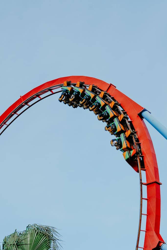 Experience the thrill of an exhilarating roller coaster loop on a bright blue sky day.