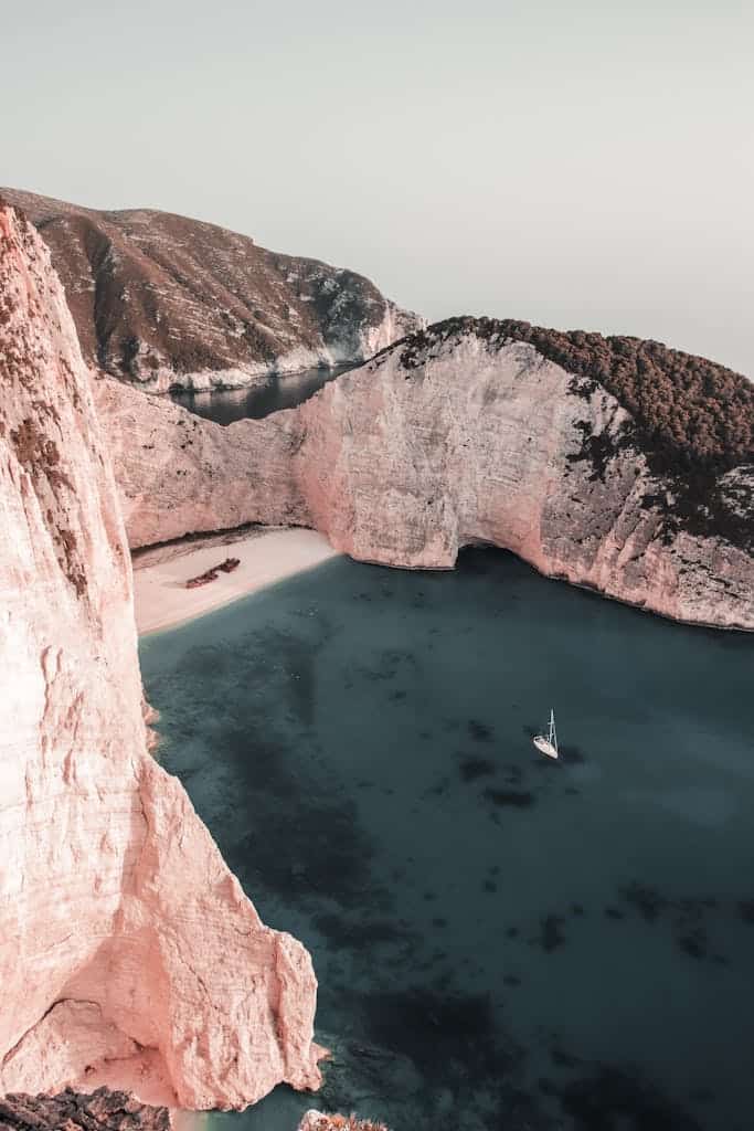 Explore the breathtaking cliffs and azure waters of Navagio Beach in Greece from above.