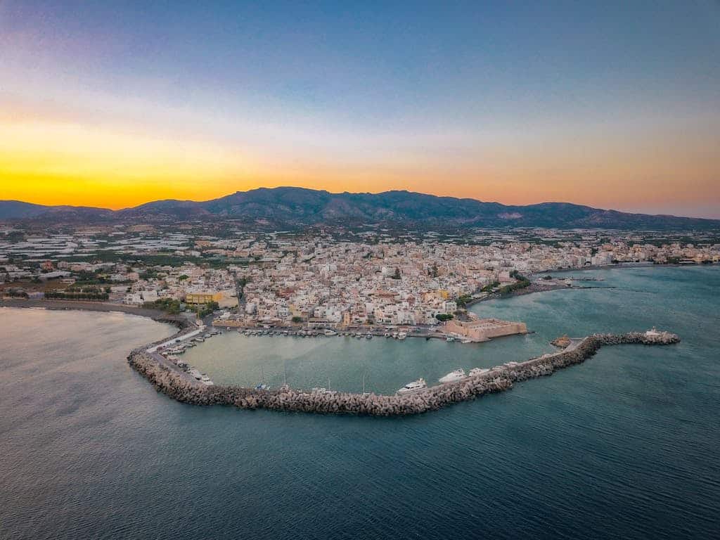 Breathtaking aerial shot of Ierapetra harbor and cityscape during the sunset in Greece.