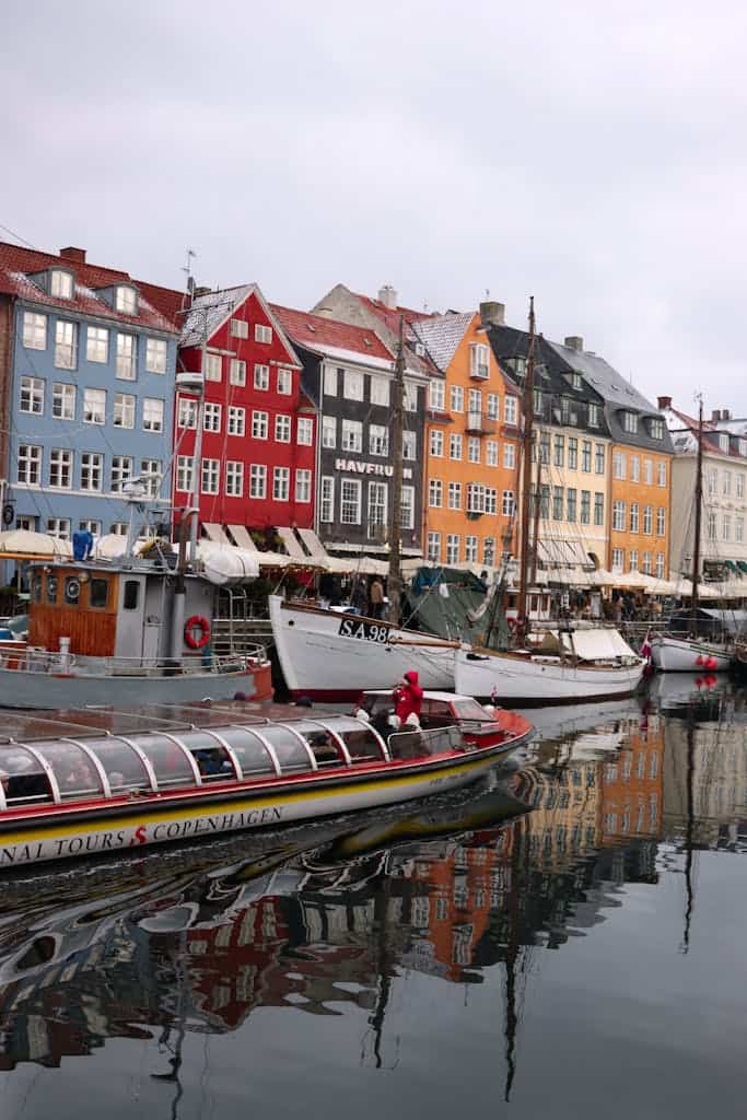 Scenic view of Nyhavn Canal in Copenhagen with colorful buildings and boats.