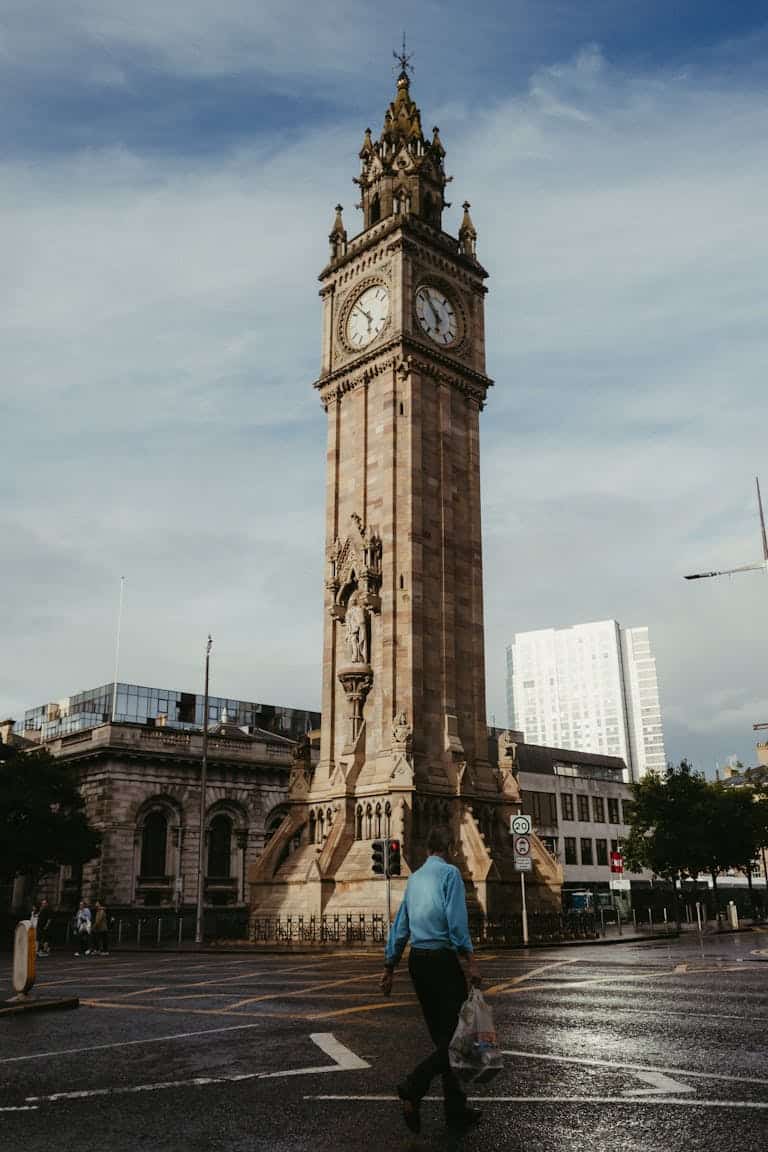 The iconic Albert Memorial Clock tower in Belfast, Northern Ireland, under a cloudy sky.