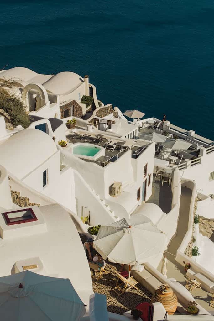 A scenic aerial view of iconic white architecture in Santorini, Greece against blue waters.